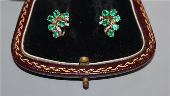 A pair of yellow metal, emerald and diamond cluster scroll earrings, 15mm.